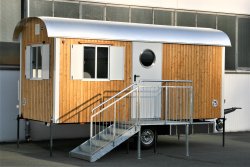 WEIRO®  Waldkindergarten-Bauwagen mit 5 m Aufbaulänge, Dachüberstand, Tür mit rundem Glasausschnitt  und Propangasheizung.