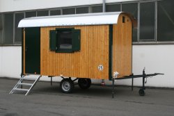WEIRO® SOLID mit 4 m Aufbaulänge, Zugöse, Stützrad, Dachüberstand, Holz-Drehkippfenster mit Fensterläden. Tür, Eckprofile und Fensterläden in individueller Lackierung.