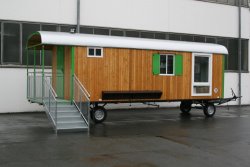 WEIRO® SOLID mit 9 m Aufbaulänge, Zugöse, Dachüberstand, Eingang mit überdachtem Podest, Treppe mit Geländern, bodentiefes Kst.-Drehkippfenster, KSt.-Schiebefenster, Außengarderobenleiste.