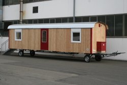 WEIRO® SOLID mit 9,40 m Aufbaulänge, Zugöse, Dachüberstand, Gasflaschenkasten, Propangasheizung, Treppe mit Geländer, KSt.-Drehkippfenster mit Rollladen, Tür mit Glasausschnitt. Individuelle Lackierung von Eckprofilen, Tür und Fensterläden.