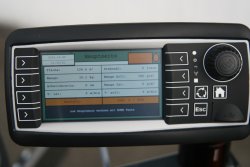 <br>LC-Display am Fahrerplatz zur Eingabe der Arbeitsparameter, z. B. gewünschte Auftragsmenge, und Überwachung des Anspritzvorgangs.<br><p1>Die hier abgebildete Maschine enthält Sonderausstattungen.