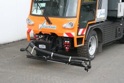 <br> Hydraulisch positionierter Düsenkopf mit einer Düse für die Naht- und Randversiegelung mit Heißbitumen oder anderen geeigneten Werkstoffen, vorn am Vorbautenträger montiert.