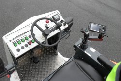 <br>Ergonomisch gestalteter Fahrerplatz, Fahrsteuerung über den Fahrhebel mit Funktionstasten. Option: Rechnergestützte Dosiersteuerung SPRAYCONTROL V4 mit LCD-Steuereinheit rechts vom Fahrerplatz zur genauen Regelung des Bindemittelauftrags (kg/m²), unabhängig von Fahrgeschwindigkeit und Arbeitsbreite. <br><p1>Die hier abgebildete Maschine enthält Sonderausstattungen.
