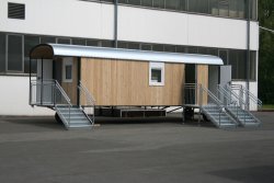 WEIRO® Waldkindergarten-Bauwagen mit 8 m Aufbaulänge, mit überdachtem Eingang mit Podest, zusätzlichem Notausgang und separatem Toilettenraum.