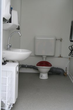 Example of separate toilet compartment accessible from outside with toilet and washbasin, mounted so they can be used by children.