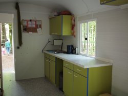 Furnishing example with small kitchen with hanging cupboard, tabletop, stainless steel sink including electric cooker with two hotplates.