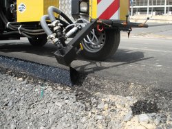<br>The nozzle head for sealing the seam ensures that the bitumen is applied evenly and cleanly to the seam area (pictured: sealing the outer edge of the asphalt surface). <br><p1>The machine shown here contains special equipment.