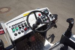 <br>Ergonomically designed driver's place, driving control via the driving lever with function keys. Option: Computer-aided dosing control SPRAYCONTROL V4 with LCD control unit to the right of the driver's seat for precise control of the binder application rate (kg/m²), independent of driving speed and working width. <br><p1>The machine shown here contains special equipment.